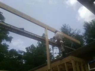 Carpenter setting a ridge beam over a new addition frame — Ice Dam Removal by Roofing Brothers in Chelmsford