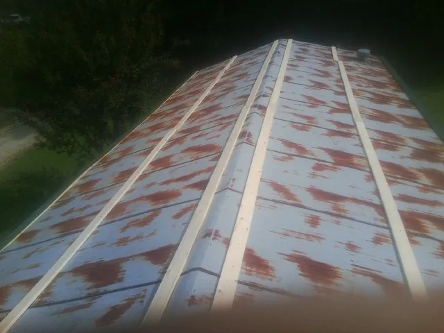 Rusted metal roof panels with new wood purlins before replacement — Storm Damage Roof Repair in Chelmsford by Roofing Brothers