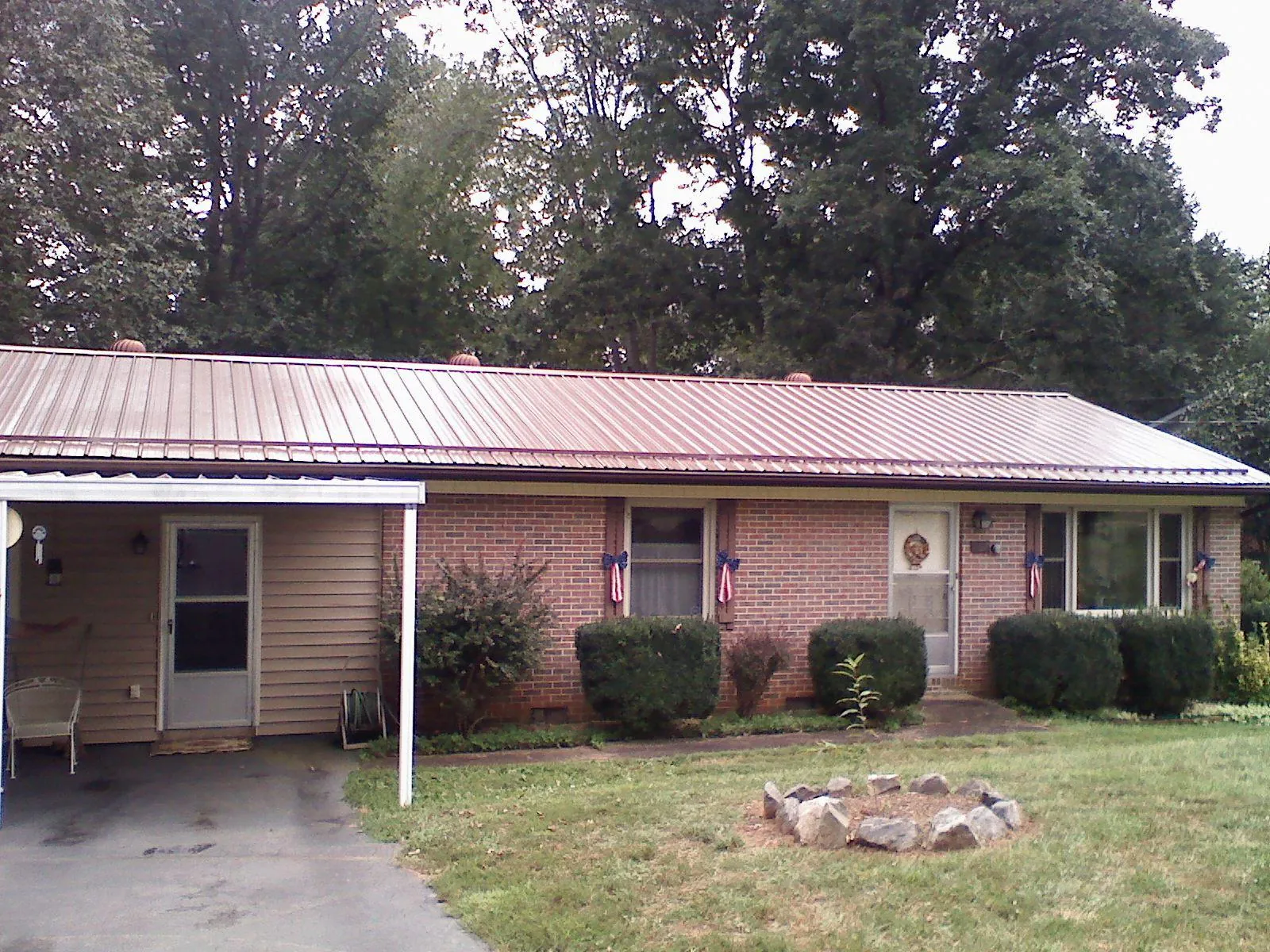 Bronze metal roof and carport on a brick ranch home — Roof Repair work by our crew in Chelmsford